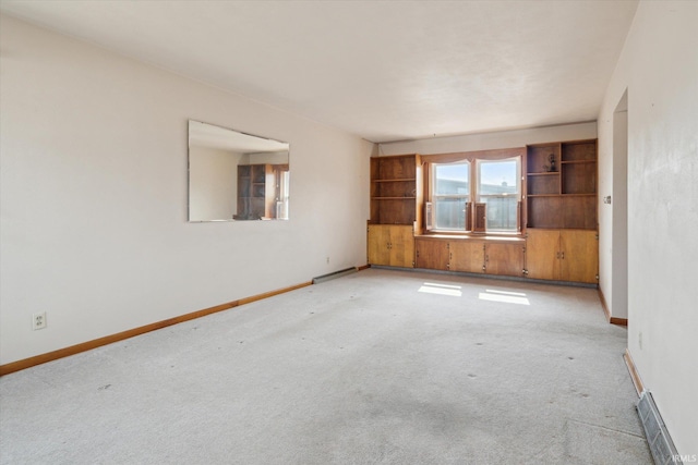 unfurnished room featuring visible vents, baseboards, and light colored carpet