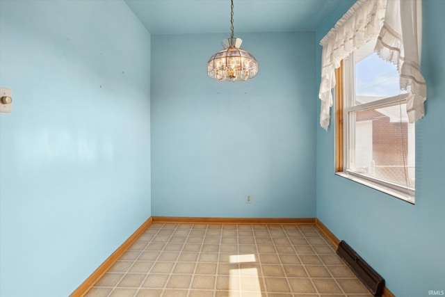 unfurnished room featuring baseboards and a notable chandelier