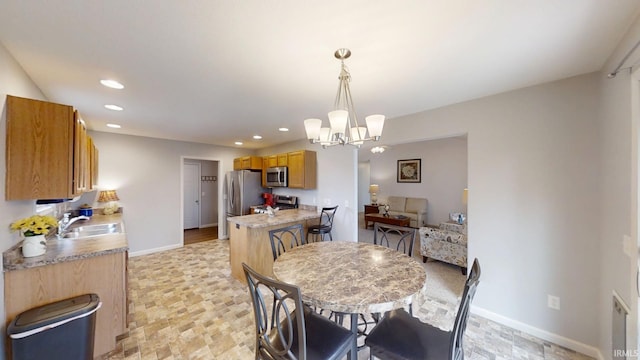 dining area featuring stone finish floor, baseboards, a notable chandelier, and recessed lighting