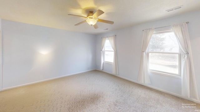 empty room featuring carpet, visible vents, ceiling fan, and baseboards