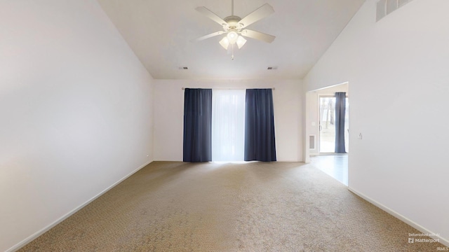 unfurnished room featuring carpet, lofted ceiling, visible vents, a ceiling fan, and baseboards