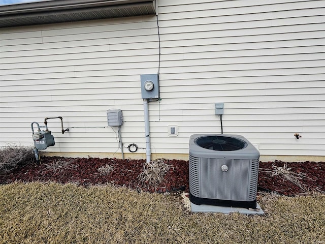 details with electric meter, central AC unit, and gas meter