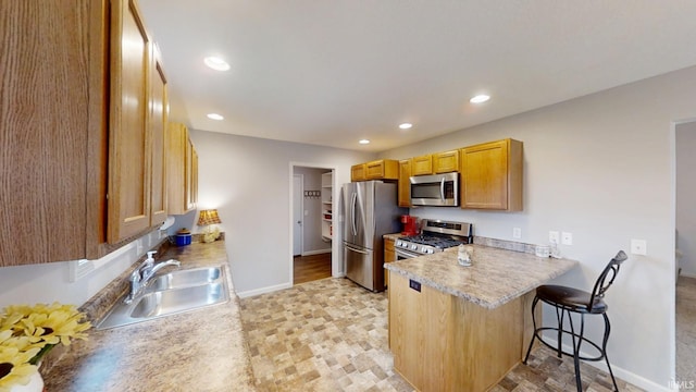 kitchen featuring recessed lighting, appliances with stainless steel finishes, a sink, a peninsula, and a kitchen breakfast bar