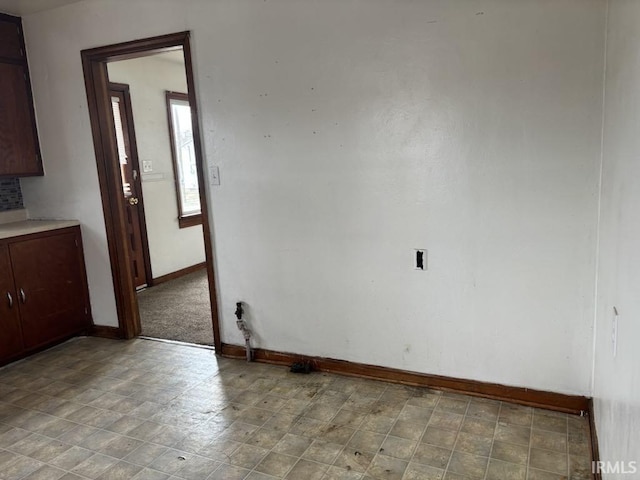 unfurnished room with baseboards