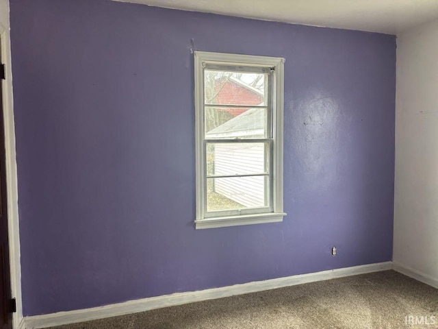 unfurnished room with carpet flooring and baseboards