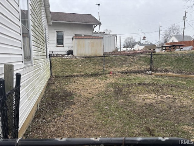 view of yard with an outbuilding, fence, and a shed