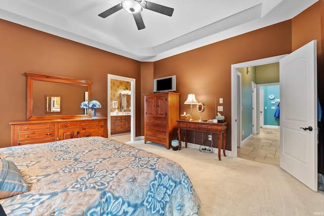 carpeted bedroom with connected bathroom, ceiling fan, and baseboards