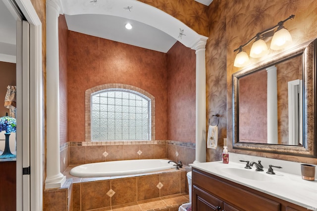 full bathroom with ornate columns, a bath, and vanity