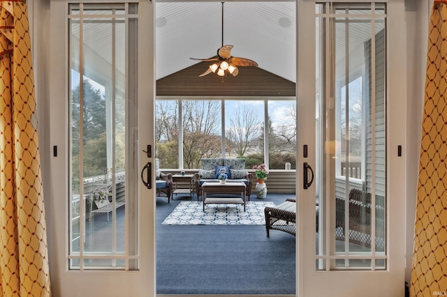 doorway with a ceiling fan and lofted ceiling