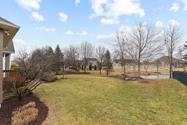 view of yard featuring a water view and fence