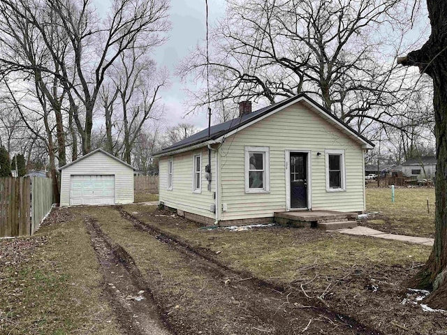 bungalow-style house with a chimney, fence, a garage, driveway, and an outdoor structure