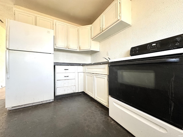 kitchen with a textured wall, dark countertops, white appliances, and concrete floors