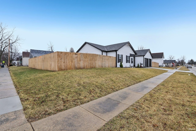 view of side of property with fence and a lawn