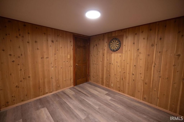 spare room featuring baseboards and wood finished floors