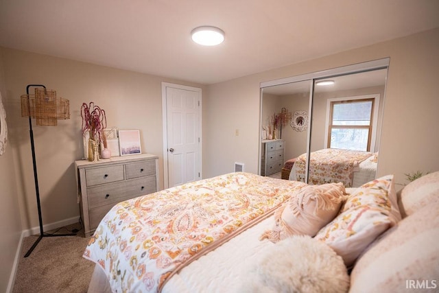 carpeted bedroom featuring a closet, visible vents, and baseboards