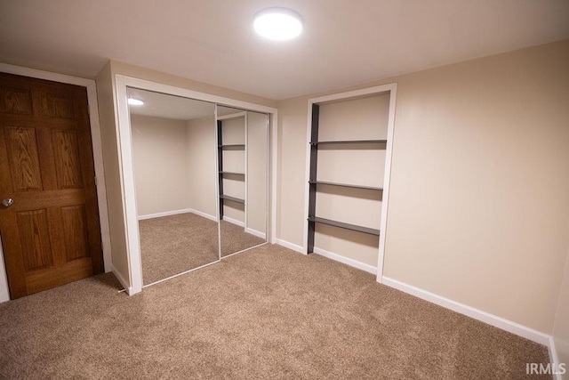 unfurnished bedroom featuring carpet, baseboards, and a closet