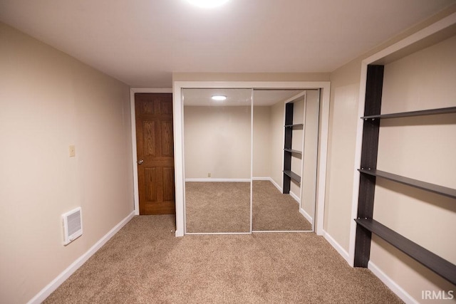 unfurnished bedroom with visible vents, a closet, baseboards, and carpet flooring