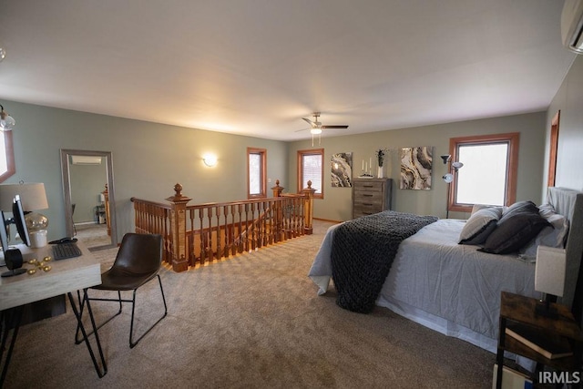 bedroom featuring an AC wall unit, light carpet, and multiple windows