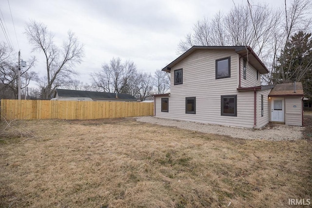 back of house featuring a yard and fence