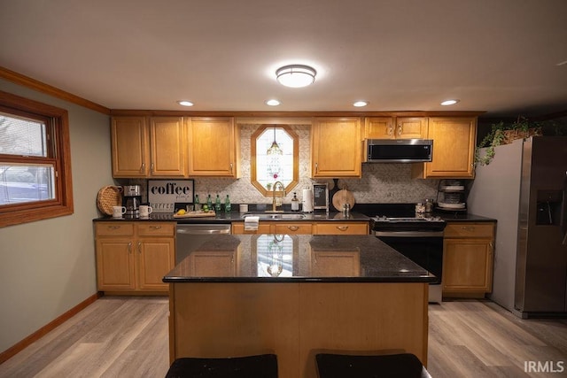 kitchen featuring backsplash, a kitchen island, stainless steel appliances, and a sink