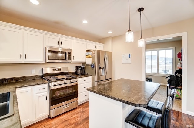 kitchen featuring appliances with stainless steel finishes, white cabinets, and light wood finished floors