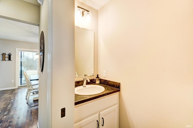 bathroom with wood finished floors, vanity, and baseboards