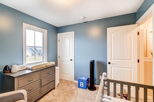 bedroom featuring light carpet and baseboards