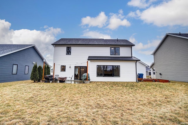 rear view of house with a patio and a yard