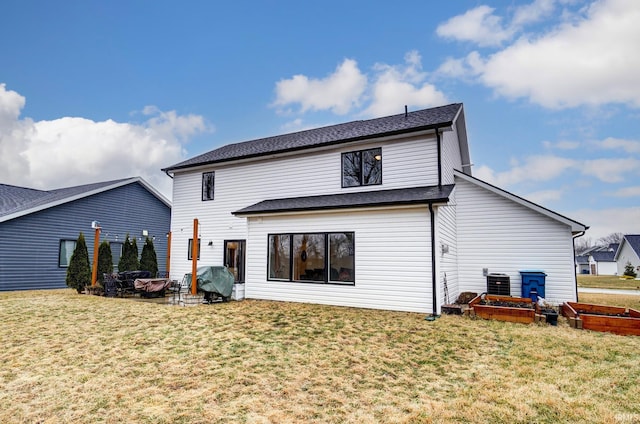 back of property featuring a vegetable garden, central AC, and a yard