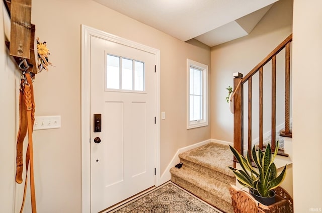 foyer with stairway and baseboards