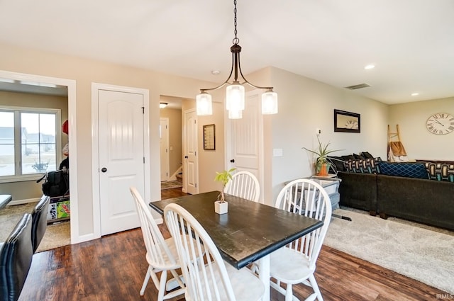 dining space featuring stairs, dark wood-type flooring, visible vents, and baseboards