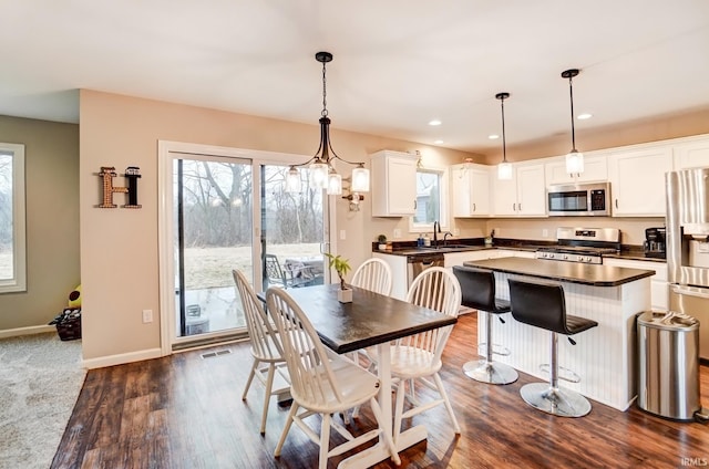 dining area featuring dark wood-style floors, recessed lighting, visible vents, a chandelier, and baseboards