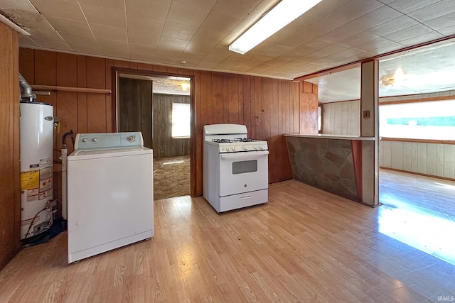 kitchen featuring water heater, brown cabinetry, washer / dryer, light wood-type flooring, and white gas range oven