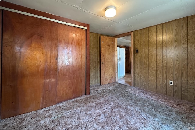 carpeted spare room featuring wooden walls