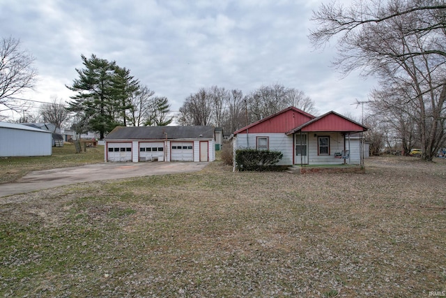 view of front of home featuring covered porch, a detached garage, and an outbuilding