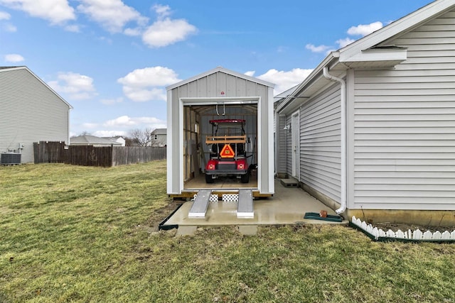 view of outbuilding featuring an outbuilding, central AC, and fence