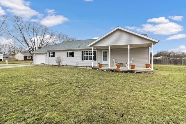 rear view of house with a garage, fence, a porch, and a lawn