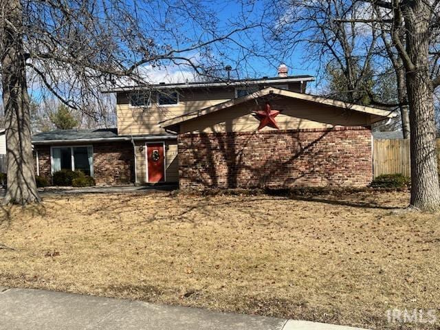 view of front of property featuring brick siding and fence