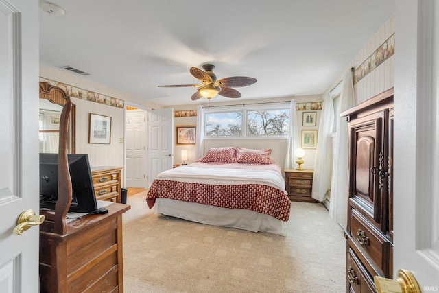 bedroom featuring light colored carpet, visible vents, and ceiling fan