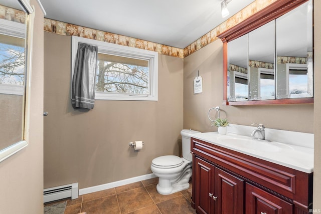 bathroom with toilet, vanity, baseboards, baseboard heating, and tile patterned floors