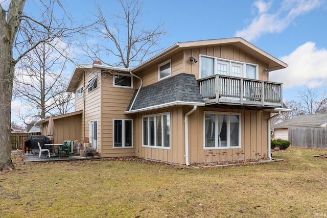 back of property with a shingled roof, a yard, a patio, and fence