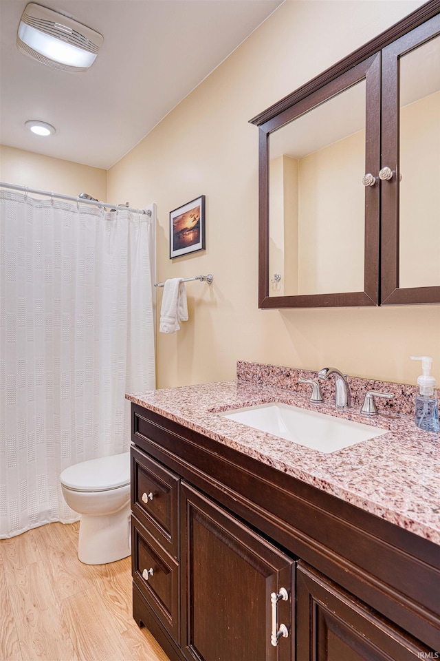 bathroom featuring toilet, visible vents, wood finished floors, and vanity