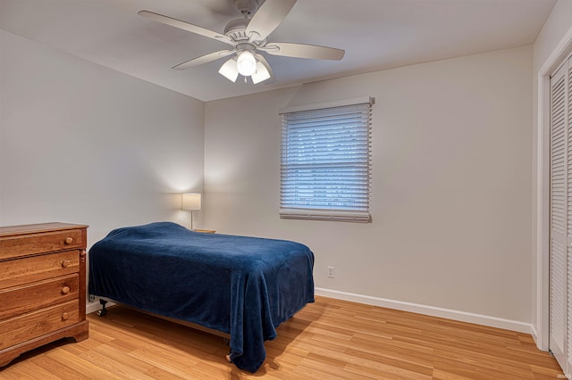 bedroom featuring light wood-style floors, a closet, ceiling fan, and baseboards