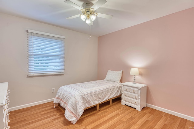 bedroom with ceiling fan, light wood-type flooring, and baseboards