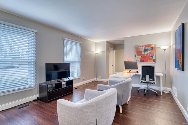 living area featuring visible vents, baseboards, and wood finished floors