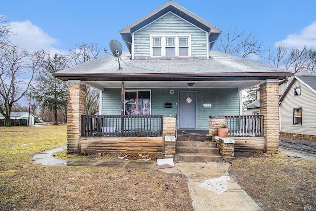 bungalow with a front yard and covered porch