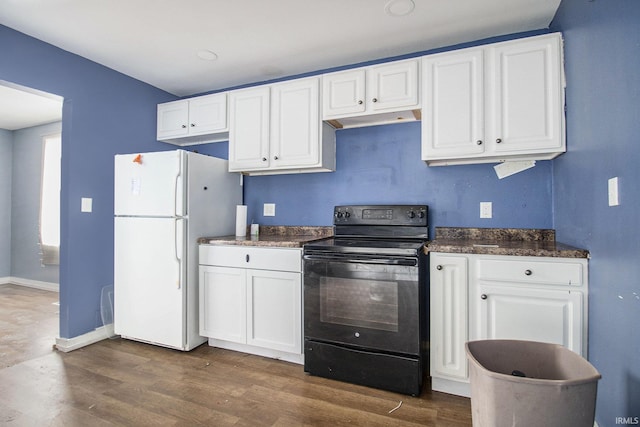 kitchen featuring dark countertops, electric range, white cabinets, and freestanding refrigerator