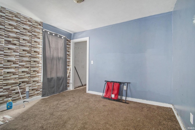 carpeted spare room featuring baseboards