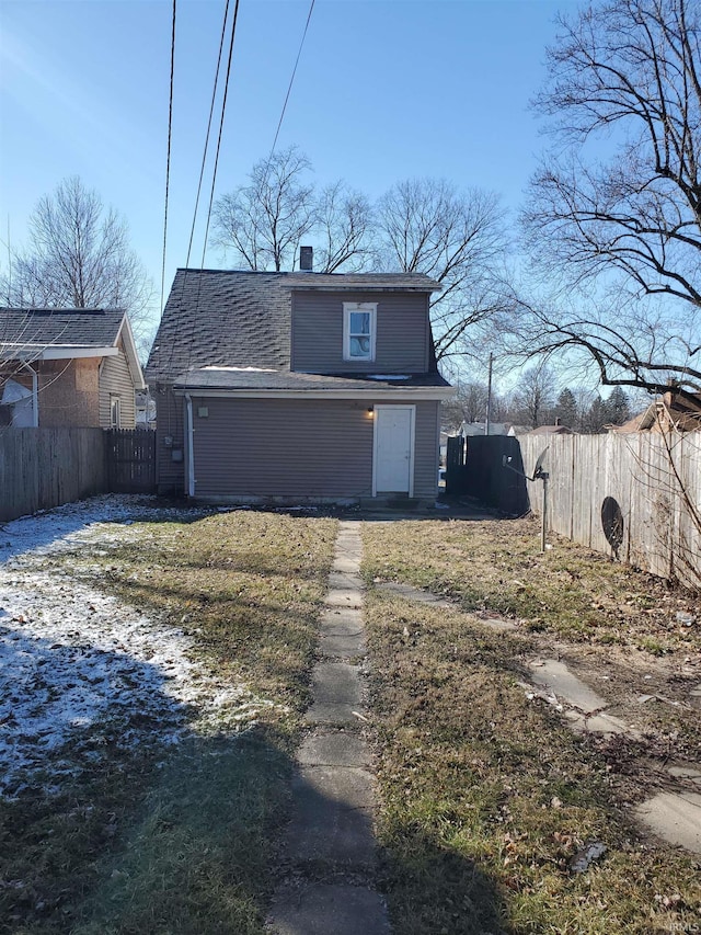 view of front of property with roof with shingles, a chimney, and fence