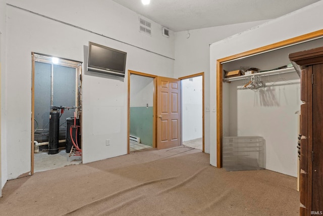 unfurnished bedroom featuring carpet floors, baseboard heating, a closet, and visible vents